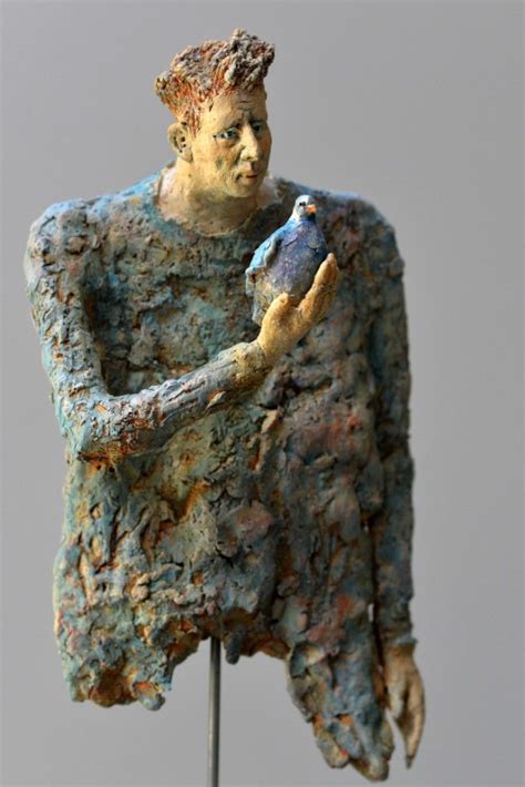 A Sculpture Of A Man Holding A Bird