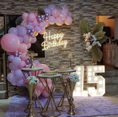 A Birthday Party Setup With Balloons And Tables In Front Of A Sign That