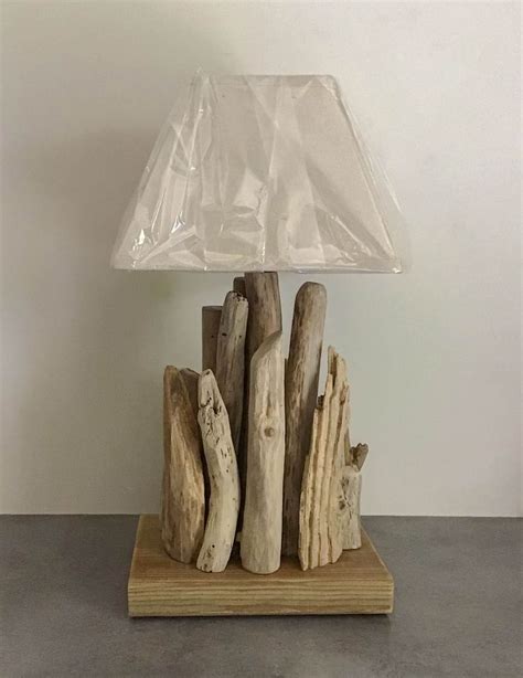 A Table Lamp Made Out Of Driftwood On A Wooden Base With A Clear