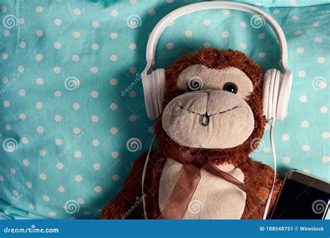 Fluffy Monkey Toy with Headphones and a Smartphone on a Green Blanket Stock Image - Image of ...