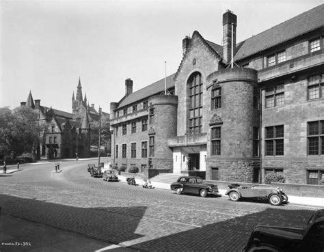 An Old Black And White Photo Of Cars Parked On The Side Of A Road In