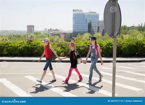 Alunos Que Atravessam A Estrada A Caminho Da Escola Foto De Stock