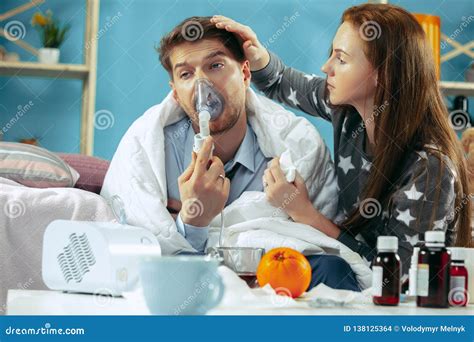 Sick Man With Fever Lying In Bed Having Temperature Girl Take Care For