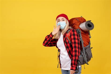 Vue De Face Belle Fille Blonde Avec Son Sac Dos Debout Sur Un Mur Jaune Photo Gratuite