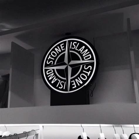 a black and white photo of a stone island sign on the wall in a shop