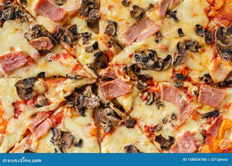 Freshly Baked Large Pizza With Ham Mushrooms And Mozzarella On A