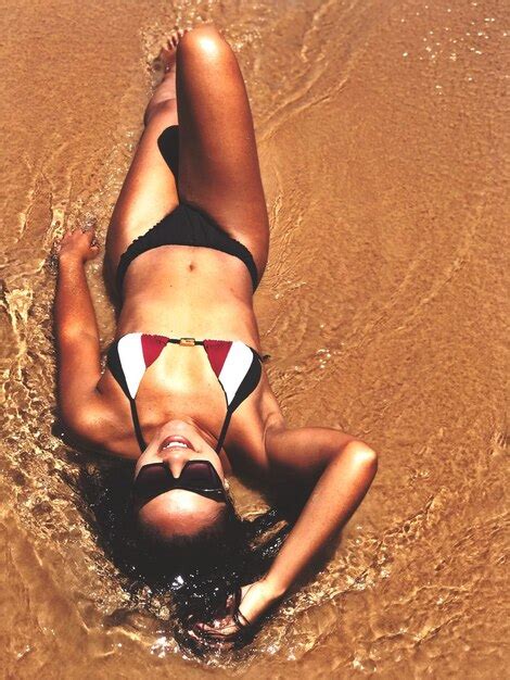 Vista de alto ángulo de una mujer en bikini acostada en la playa Foto