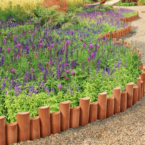 The Garden Is Full Of Purple Flowers And Green Plants In Clay Planters