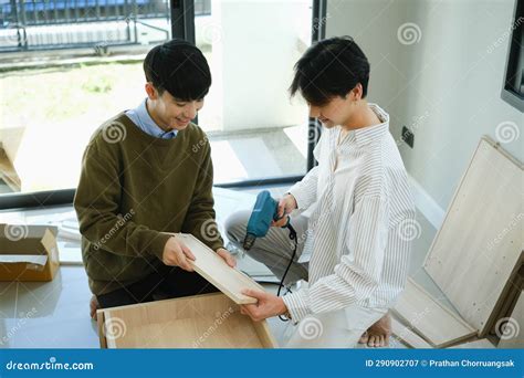 Cheerful Gay Couple Moving In New Home And Assembles Furniture Together LGBTQ Relocation And