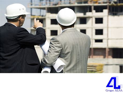 Two Men In Suits And White Hard Hats Standing Next To Each Other