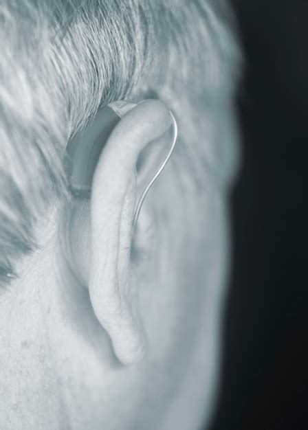 Premium Photo Close Up Man Wearing Hearing Aid Against Black Background