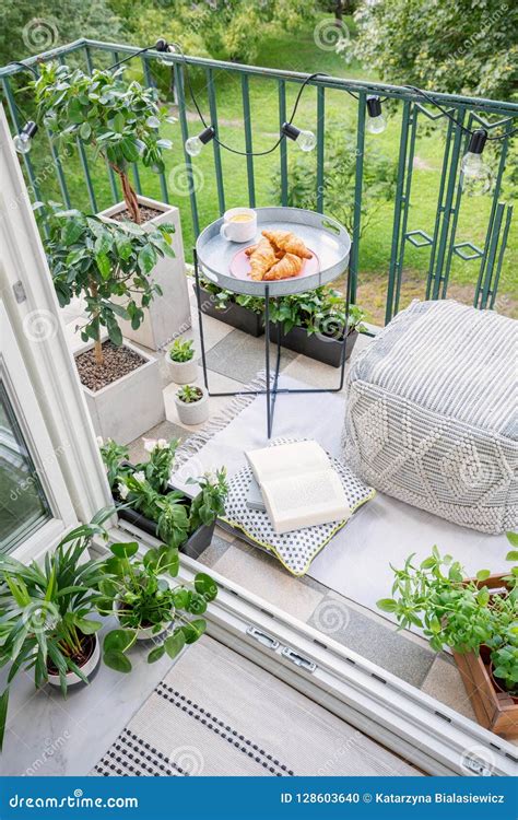 Space for Meal and Relaxation on a Green Balcony with a Comfy Ottoman ... 