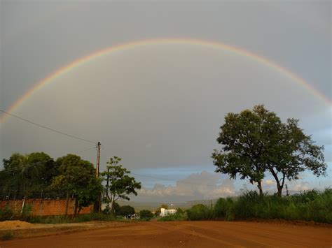 A double rainbow in the sky over a dirt road photo – Free Palmas Image ...