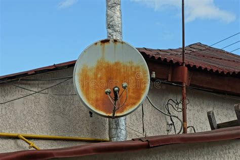 Un Viejo Y Oxidado Plato Satelital En La Pared De Una Casa Imagen De