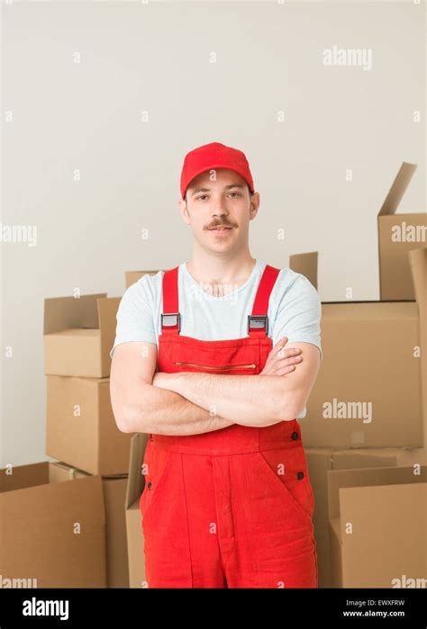 Young Confident Delivery Man Standing Holding Hands Crossed Against