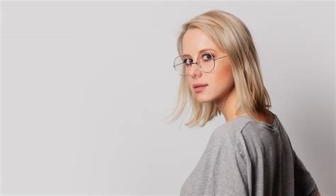 Premium Photo Serious Blonde Woman In Glasses On White Wall