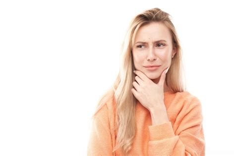 Premium Photo Smart Blonde Girl In Casual Holding Chin Thinks Doubts