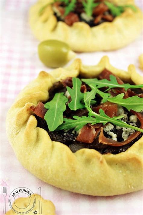 Two Small Pizzas With Toppings Sitting On Top Of A Checkered Table Cloth