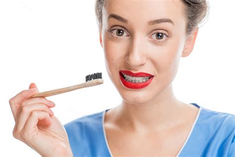 Retrato De Una Mujer Confundida Con Frenos Dentales Sosteniendo Un