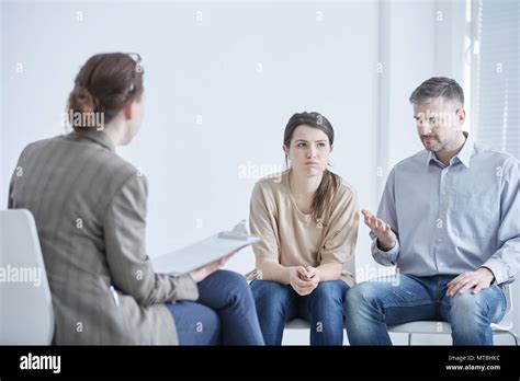 Angry Married Couple Talking With Psychologist During Therapy Stock