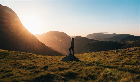 Man Standing On Top Of Rock In An Open Field At Golden Hour Image Free