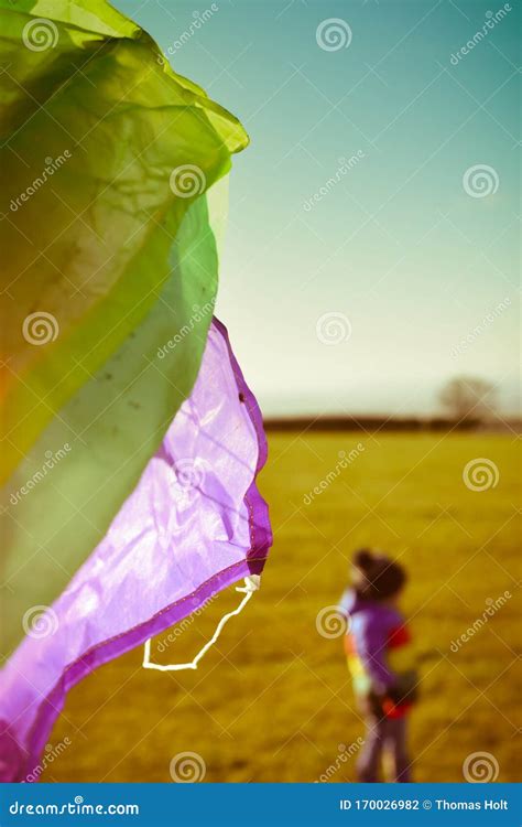 Boy Playing Outside With A Kite Running Outdoors During The Day With