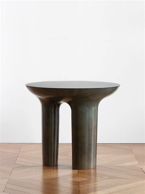 Two Round Metal Tables Sitting On Top Of A Wooden Floor In Front Of A