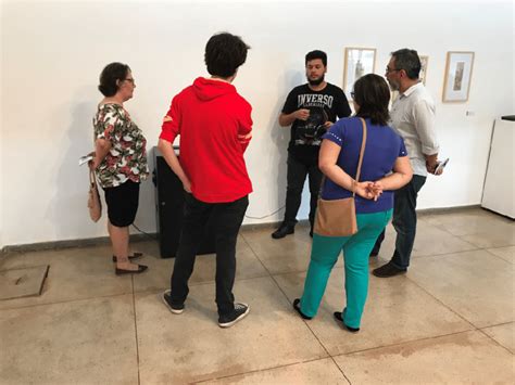 Estudante Explicando Sua Pesquisa Em Arte Para Visitantes Da Exposi O