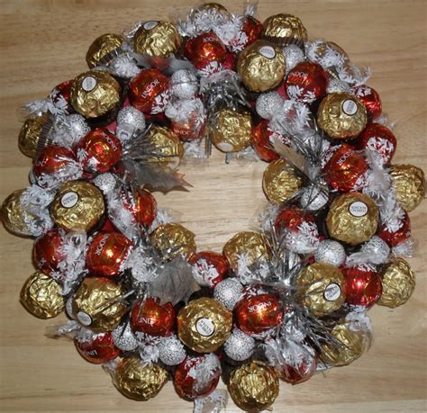 A Wreath Made Out Of Chocolates And Wrapped In Foil Wrap On Top Of A