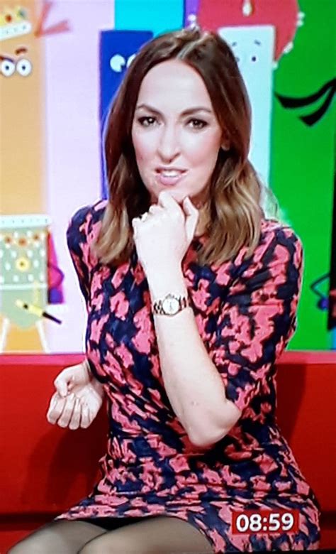 A Woman Sitting On Top Of A Red Couch In Front Of A Colorful Wall And Floor