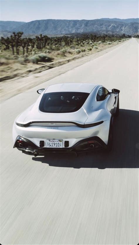 A White Sports Car Driving Down The Road