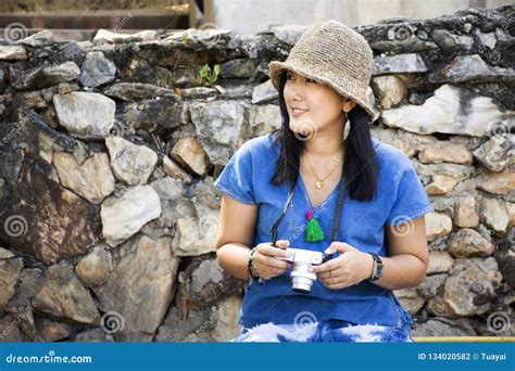 Travelers Thai Woman Travel And Sitting Relax On Trunk Bench In Pa Tueng Hot Spring At Mae Chan