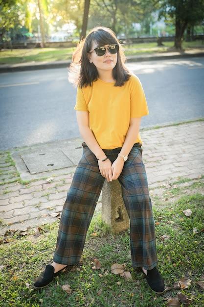 Premium Photo Young Woman Wearing Sunglasses Sitting In Park