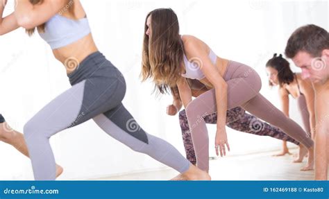 Group Of Young Sporty Attractive People In Yoga Studio Practicing Yoga