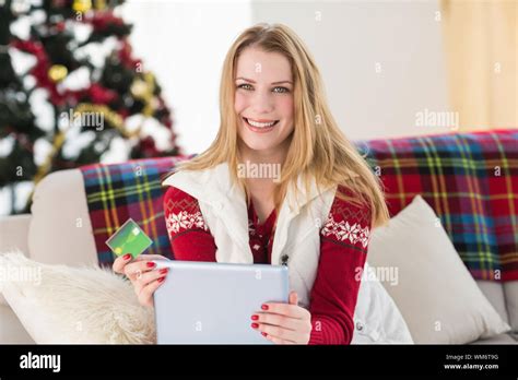 Cute Blonde Sitting On Couch Holding Credit Card And Tablet At Home In