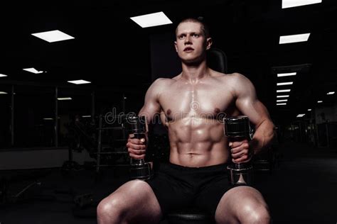 Handsome Strong Athletic Man Pumping Up Muscles With Dumbbells Muscular Bodybuilder With Naked