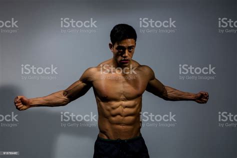 Fitness Model Displaying Biceps And Pectorals With Stretched Out Arms