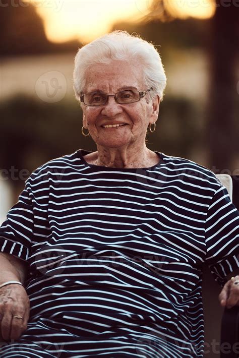 Unfiltered portrait, a real elderly woman sits gracefully in a chair