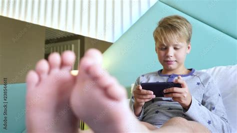 Closeup View Of Blurry Cute Small Childs Feet Boy Sitting In Bed In