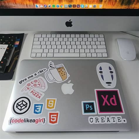 An Apple Computer Sitting On Top Of A Desk With Stickers All Over The