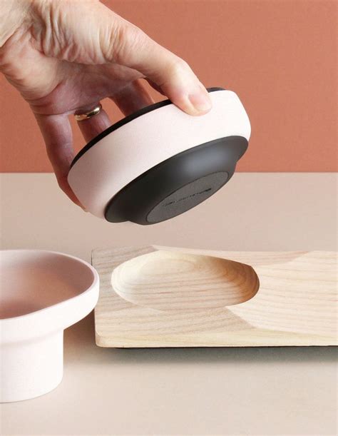 A Person Is Pouring Something Into A Cup On Top Of A Wooden Tray Next