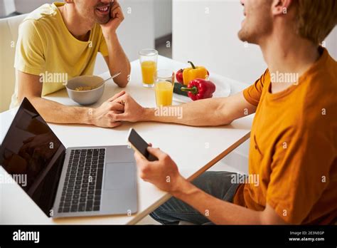 Happy Gay Couple Having Breakfast And Using Modern Devices At Home Stock Photo Alamy