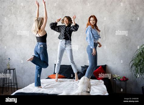 Three Young Adult Girlfriends Dressed Casual Having Fun Jumping