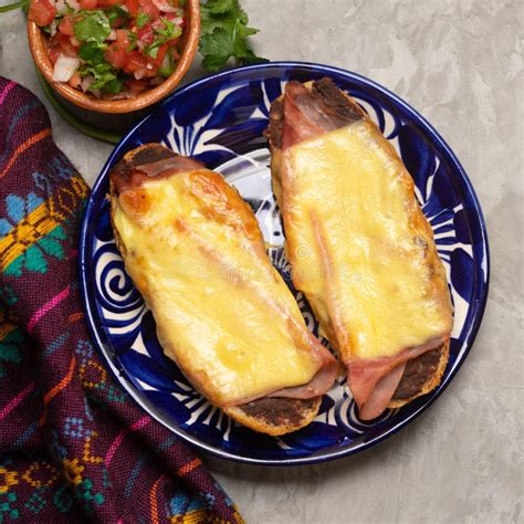 Molletes With Ham Refried Beans And Melted Cheese On A Gray Background