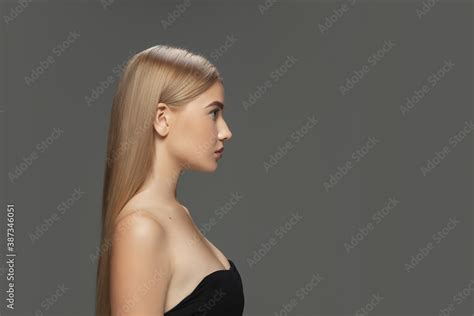 Profile Beautiful Model With Long Smooth Flying Blonde Hair On Dark Grey Studio Background