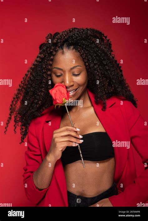 Cheerful And Romantic Young African American Model Holding A Rose Stalk