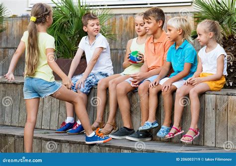 Niños Y Niñas Sentados Y Jugando Con Pelota Al Aire Libre Imagen de