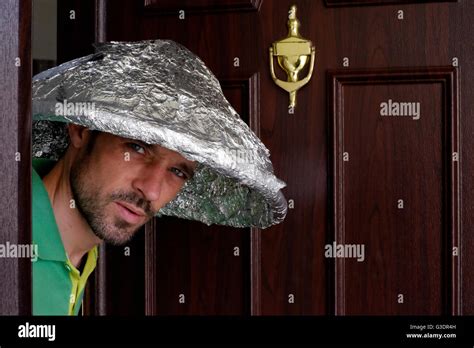 Male Conspiracy Theory Believer Wearing Tin Foil Hat Peering Out Of