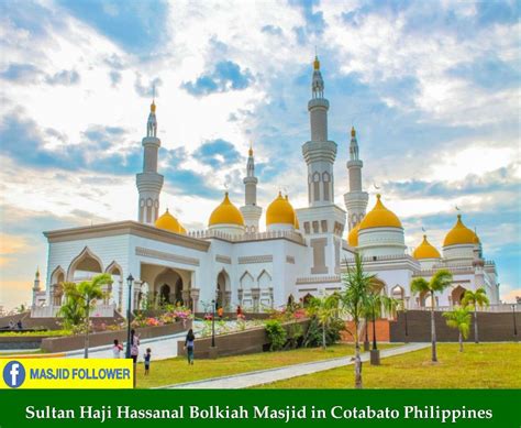 A Large White Building With Yellow Domes On Its Sides And Palm Trees