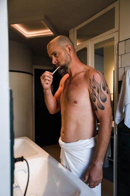 Premium Photo Handsome Man Brushing His Teeth In The Bathroom